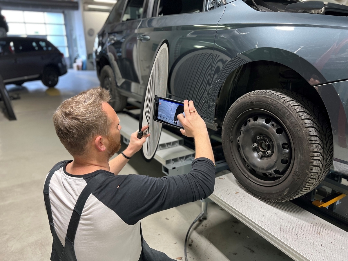 Ein Werkstattmitarbeiter von Fix Auto dokumentiert einen Fahrzeugschaden.