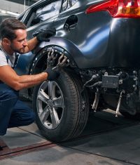 Karosseriebauer arbeitet an einem Fahrzeug