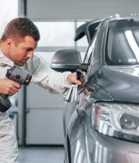 Professional worker. Man in uniform is in the auto service.