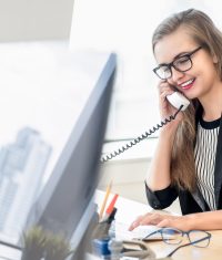 Happy businesswoman as a customer care representative talking on the phone at work with her client in the office